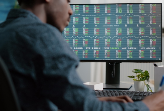 African american man looking into crypto currency stock markets trading checking stock ticker index