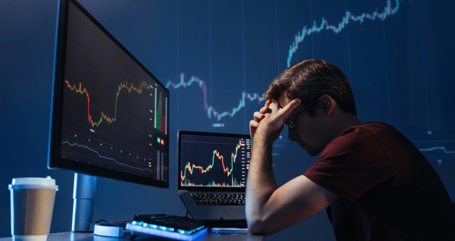 Depressed crypto investor of computer with candlestick chart of crypto currency market