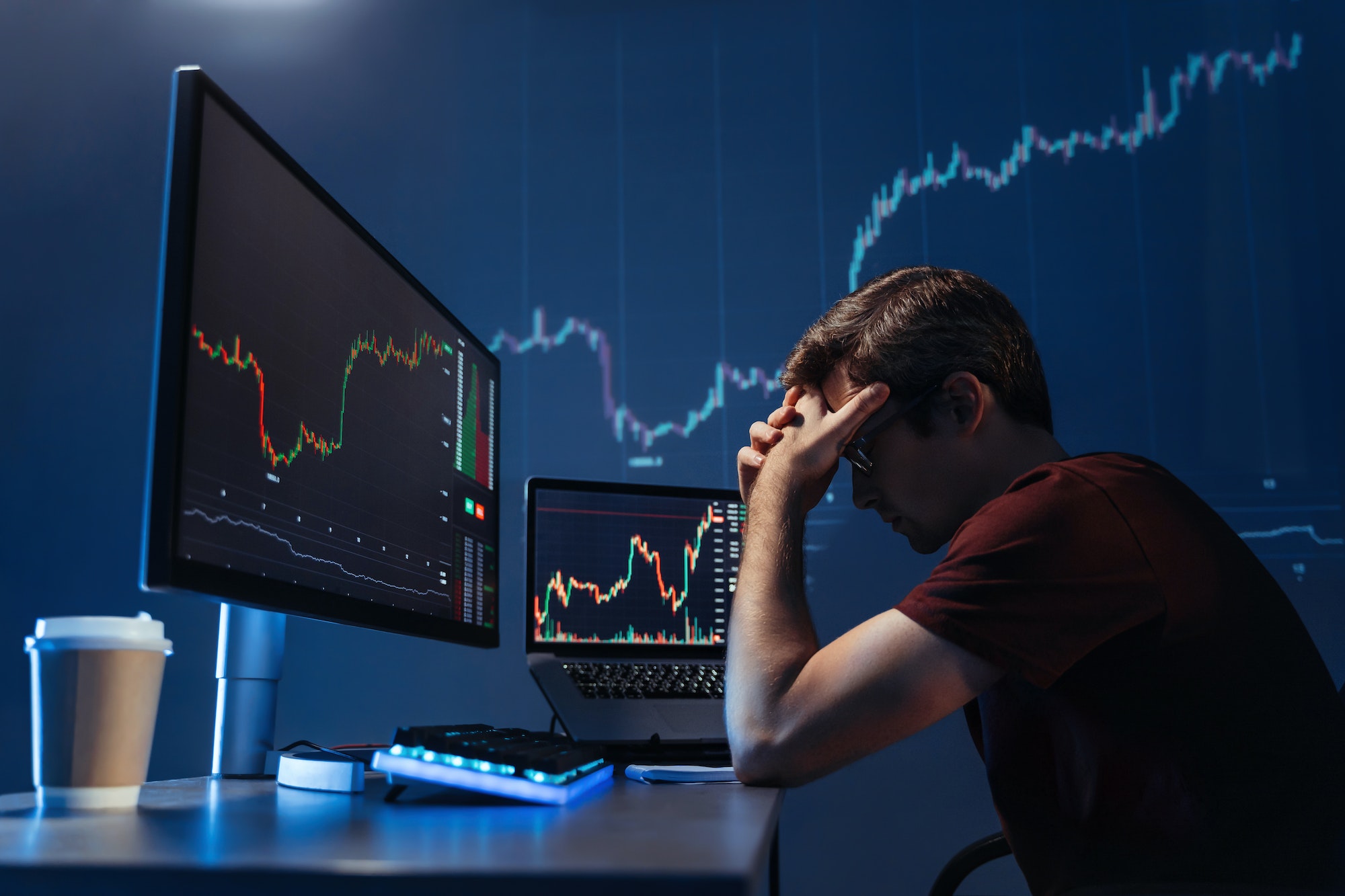 Depressed crypto investor of computer with candlestick chart of crypto currency market