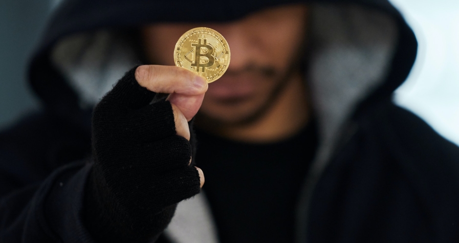 No digital print will be left behind. Shot of a scammer holding a bitcoin.